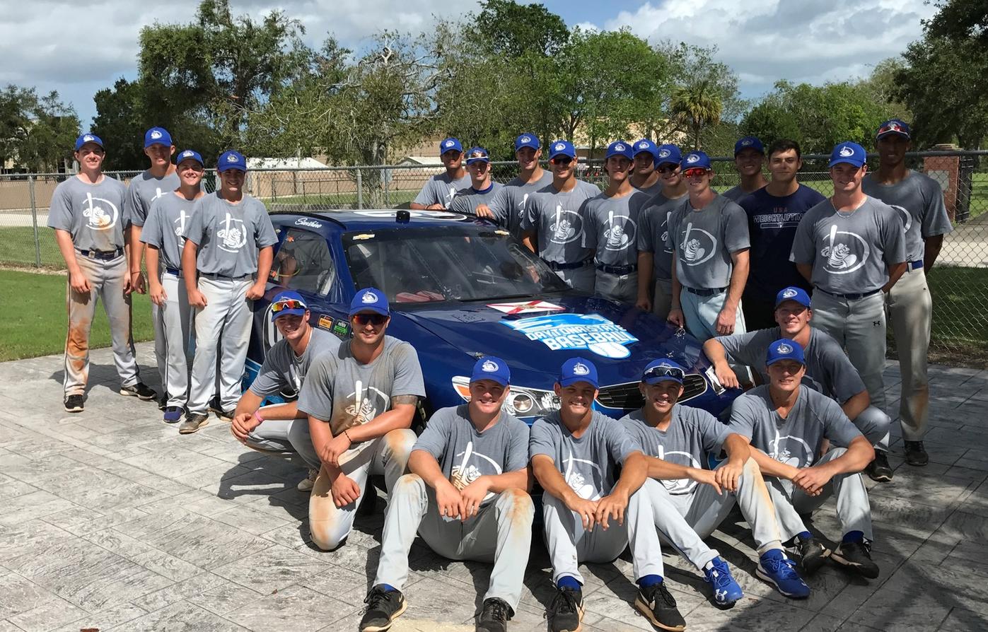 The Daytona State Baseball team gathers around the race car provided by Visit Florida Racing